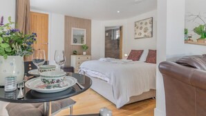 Ein modernes Schlafzimmer mit Bett, Nachttisch und Blick ins Badezimmer.