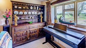 Une pièce avec un meuble en bois, un bureau avec un ordinateur portable et une fenêtre donnant sur l’extérieur.