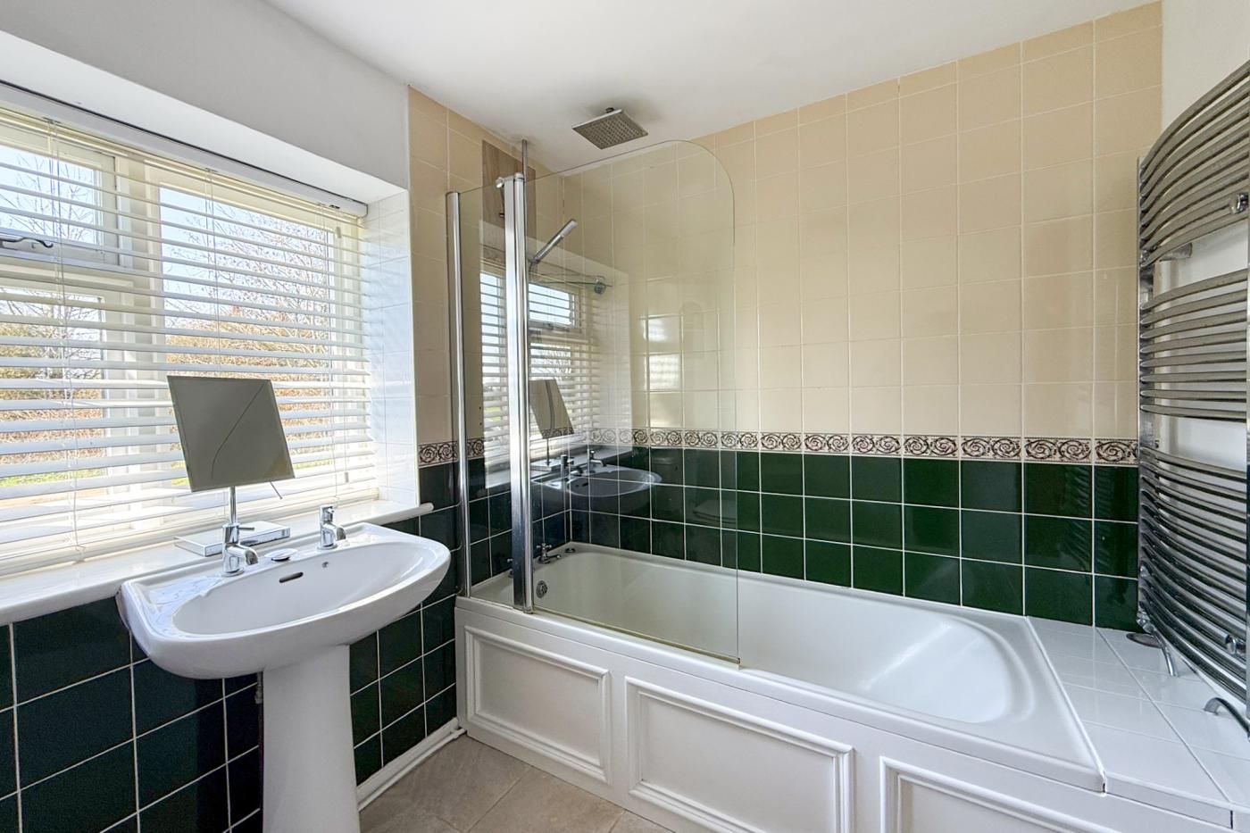 Een badkamer met een wastafel, spiegel en bad.