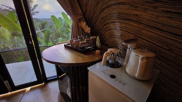 A room with a wooden table, a coffee maker, and a kettle.