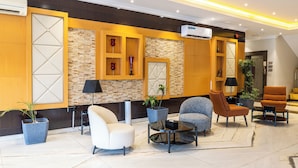A lobby with a reception desk, seating area, and a staircase. - Taleen Serviced Apartments AlQuds (Riyadh)