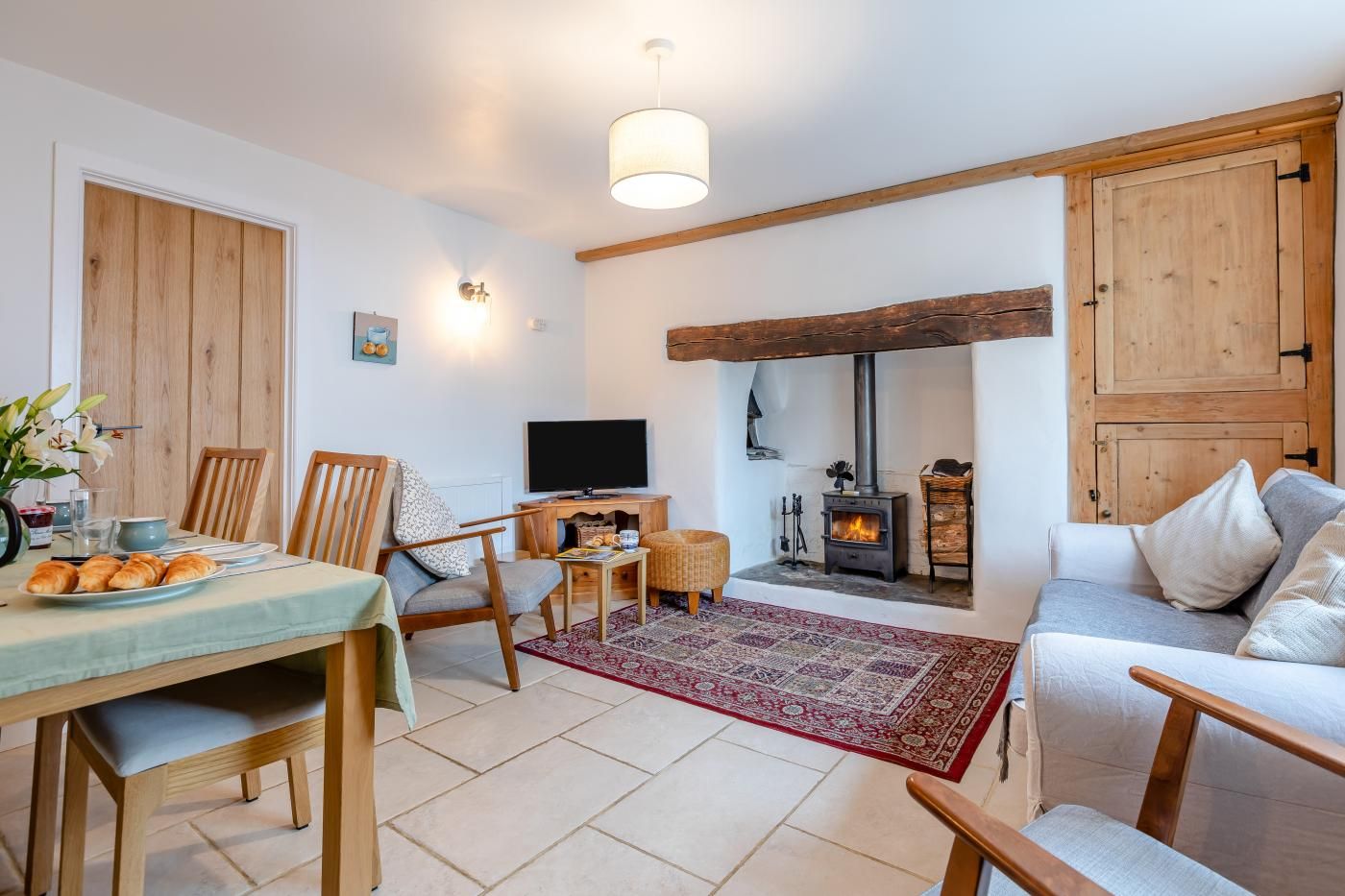 A cozy living room with a fireplace, wooden furniture, and a television.