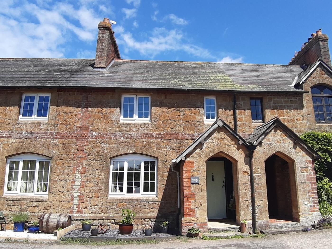 A stone building with multiple windows, a door, and a sign indicating a 'Country Inn.'