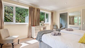 Un dormitorio con dos camas, un escritorio, una silla y una ventana con cortinas.