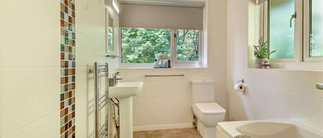 A bathroom with a toilet, sink, and bathtub.