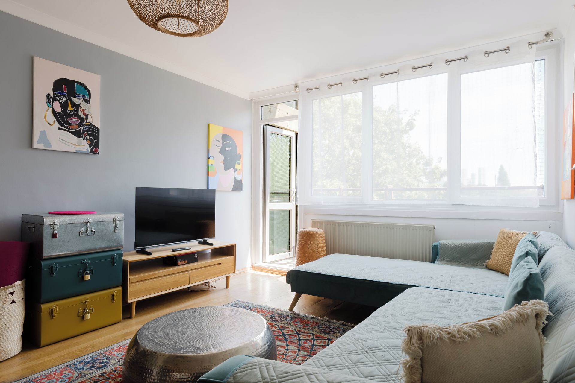 A modern bedroom with a bed, a television, and artwork on the walls.
