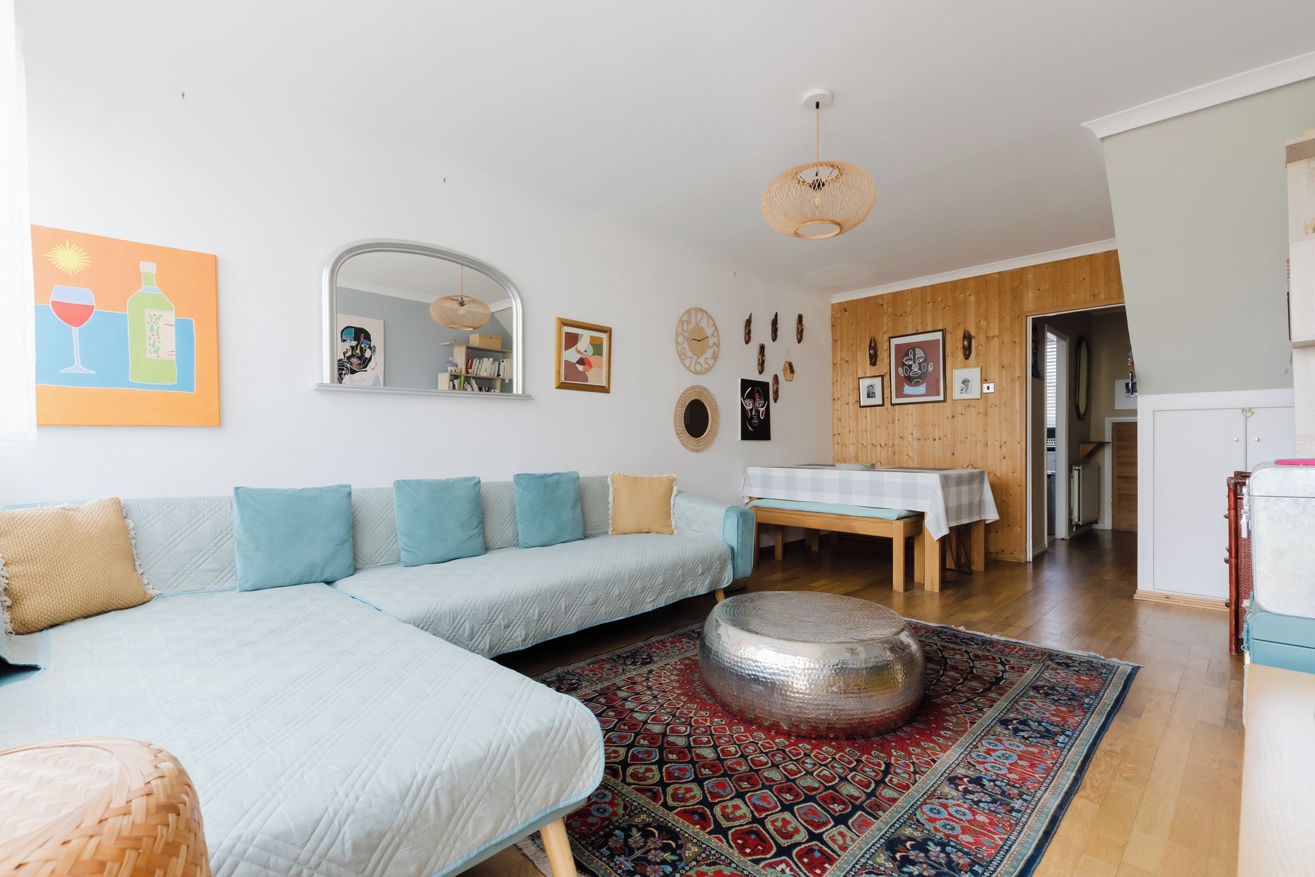 A living room with a sofa, a round table, and a patterned rug.