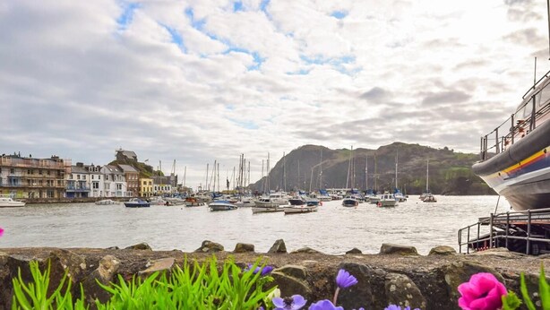 A harbor with boats, a rocky shoreline, and buildings in the background. - 3 Bed in Ilfracombe (oc-57795) (Ilfracombe)