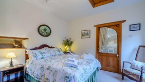 A bedroom with a bed, bedside table, lamp, and a chair. - 2 Bed in Sedbergh (oc-57641) (Dent)
