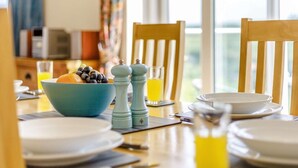 A dining table with a bowl of fruit, salt and pepper shakers, and a glass of orange juice. - 3 Bed in Morpeth (oc-63025) (Rothbury)