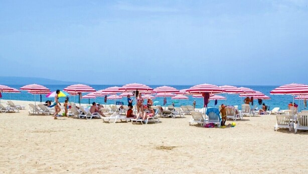 A beach with rows of sun loungers and red and white striped umbrellas. - Casa Onde Chiare - Pizzo Beach Club 16G (Contrada Difesa II)