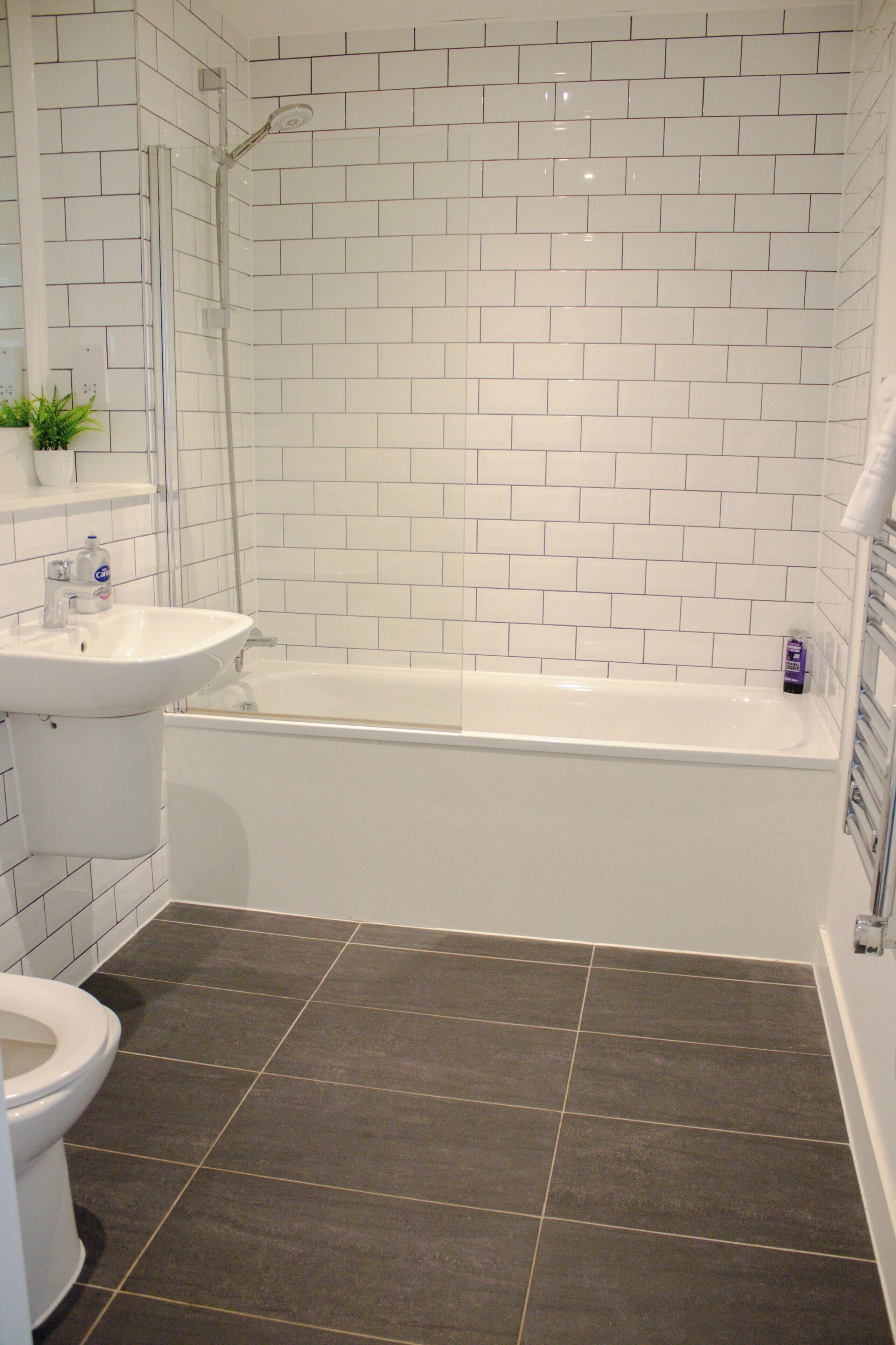 Een badkamer met een wit bad, een wastafel en een toilet.