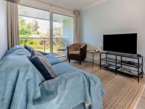 A modern living room with a sofa, a chair, a TV, and a small table. - 2 Bed in Newquay (oc-63267) (Newquay)