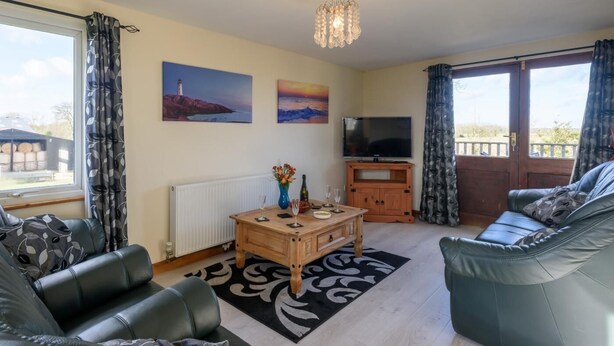 A living room with a sofa, a coffee table, a TV, and artwork on the walls. - 3 Bed in Dereham (oc-65903) (Foulsham)
