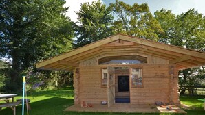 Una cabana de fusta amb teulat a dos vessants, una porta i una finestra petita.