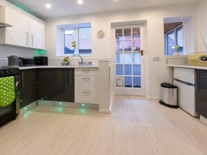 A modern kitchen with a central island, a sink, and a stove. - 1 Bed in Knaresborough (oc-66981) (Knaresborough)