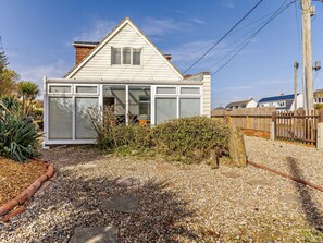 A single-story house with a gabled roof, a front porch, and a gravel driveway. - 3 Bed in Rye- (oc-72303) (Camber)