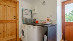 A laundry area with a washing machine, drying rack, and a sign for dog drying towels. - 3 Bed in Middlesbrough (oc-72267) (Chop Gate)