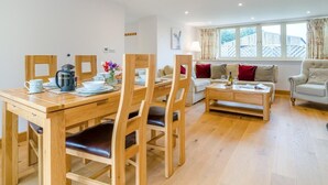 A dining area with a wooden table and chairs, a coffee maker, and a vase with flowers. - 2 Bed in Bristol (oc-72582) (Winford)