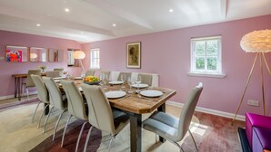 A dining room with a wooden table set for six, surrounded by chairs. - 6 Bed in Norwich (oc-72652) (Hoveton)