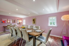 A dining room with a wooden table set for six, surrounded by chairs. - 6 Bed in Norwich (oc-72652) (Hoveton)
