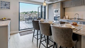 Una cocina moderna con zona de comedor, ventanas amplias y vistas al exterior.