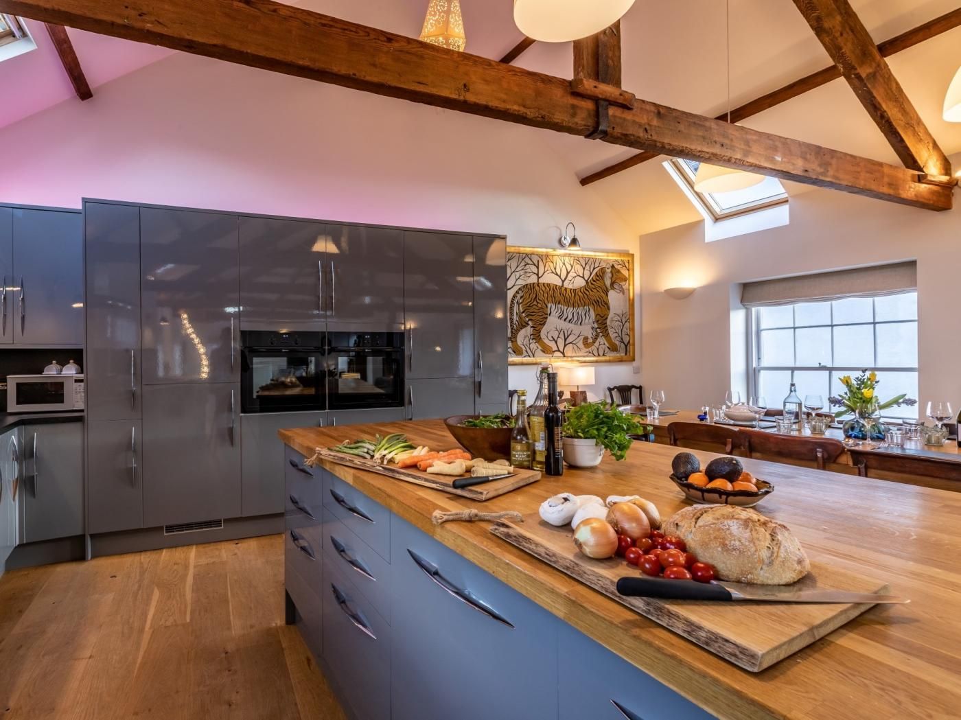 Une cuisine moderne avec un îlot central en bois, des appareils électroménagers en acier inoxydable et une grande fenêtre.