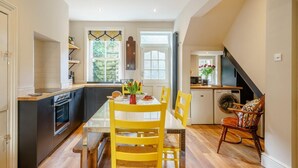 A kitchen with a dining table, chairs, and a washing machine. - 4 Bed in Harrogate (oc-73424) (Harrogate)