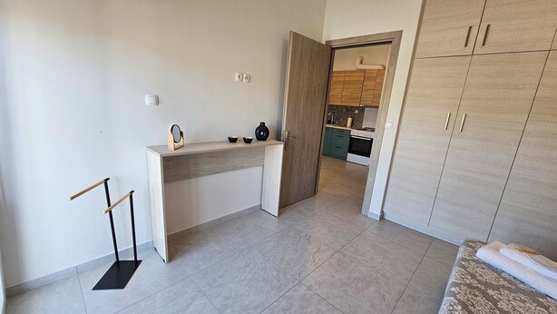 A modern kitchen with a wooden countertop, a built-in oven, and a view into the adjacent dining area. - Estia Chios Apartment B3 (Lefkonia)