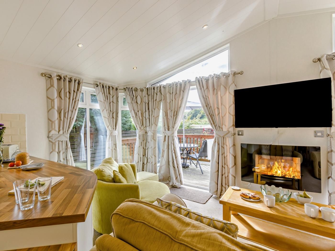 A living room with a fireplace, a television, and a dining area with a table and chairs.