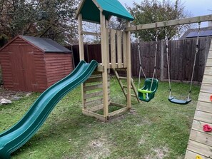 A wooden play structure with a slide and swings. - 4 Bed in Burnham-on-sea (oc-74323) (Berrow)