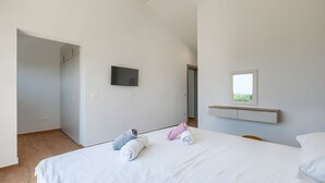 A bedroom with a bed, a TV mounted on the wall, and a window with a view. - Villa Moon - SeaView&Hydromassage by Villas Guide (Peruški)