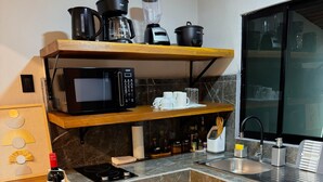 A compact kitchen with a microwave, coffee maker, blender, and a sink. - Tropical Apartments (Puerto Viejo de Talamanca)