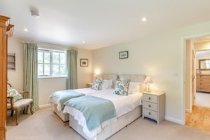 A bedroom with two beds, a nightstand, a chair, and a window with curtains. - 2 Bed in Dorchester (oc-75243) (Sydling Saint Nicholas)