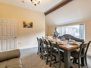 A dining room with a wooden table set for six, surrounded by chairs, a chandelier, and a painting on the wall. - 4 Bed in Bala (oc-75288) (Llandderfel)