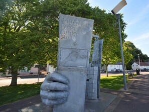 A stone monument with a handprint and text indicating it is a South West Coast Path marker.