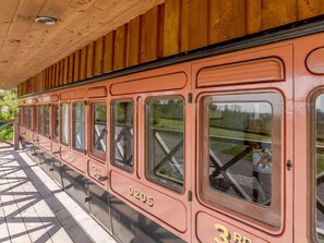 A vintage train car with the number 0205 and 3rd class designation, parked at a station with a wooden roof structure. - 1 Bed in Exeter (oc-75423) (Longdown)