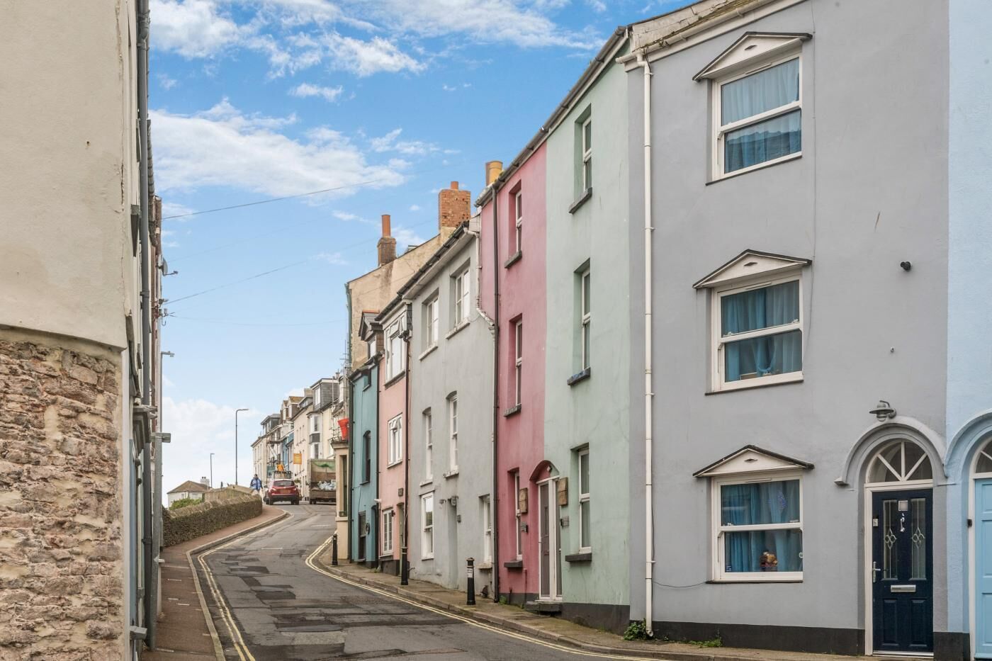 Una hilera de casas coloridas en terrazas con una calle estrecha.