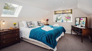 A bedroom with a bed, a dresser, a nightstand, a window with a view, and a skylight. - 4 Bed in Worcester (oc-75601) (Halmond's Frome)