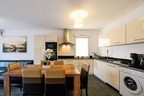 A modern kitchen with a dining area, a washing machine, and a large window. - Gold 3 Apartment (Cannes)