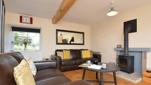 Un salon avec un canapé, une table basse, une cheminée et une horloge au mur.