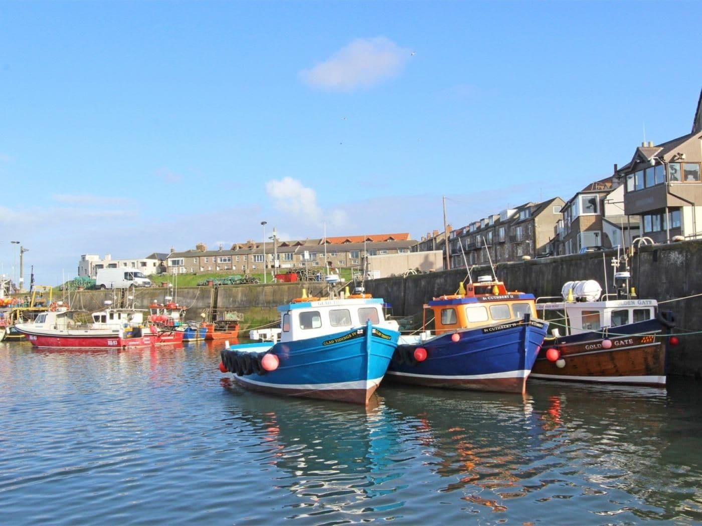 A harbor with boats docked, a waterfront building, and a clear sky.