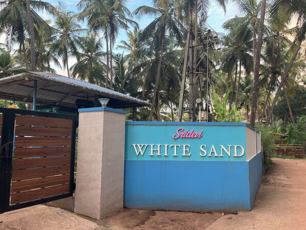 A sign for 'White Sand' with a blue background and white lettering.