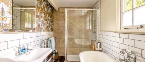A bathroom with a shower, a sink, and a bathtub.