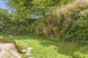 Ein üppiger Garten mit einem gepflasterten Weg, der hindurchführt.