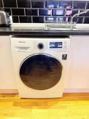 Eine Samsung Digital Inverter Waschmaschine mit Bedienfeld, Digitalanzeige und einer Frontlader-Türe.