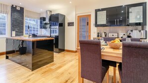 A modern kitchen with a dining area, featuring a central island, built-in appliances, and a view through the window. - 2 Bed in Battle (oc-77491) (Battle)