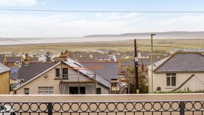 A residential area with houses, a clear sky, and a distant view of the sea. - 2 Bed in Bideford (oc-77589) (Northam)