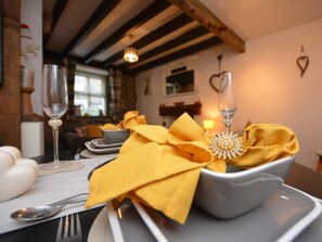 A dining table set with a white bowl, a yellow napkin, and a silver spoon. - 1 Bed in Caernarfon (oc-77891) (Llanaelhaearn)