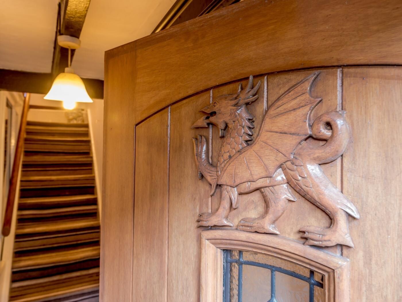 Een houten deur met een gedecoreerd drakenwapen.